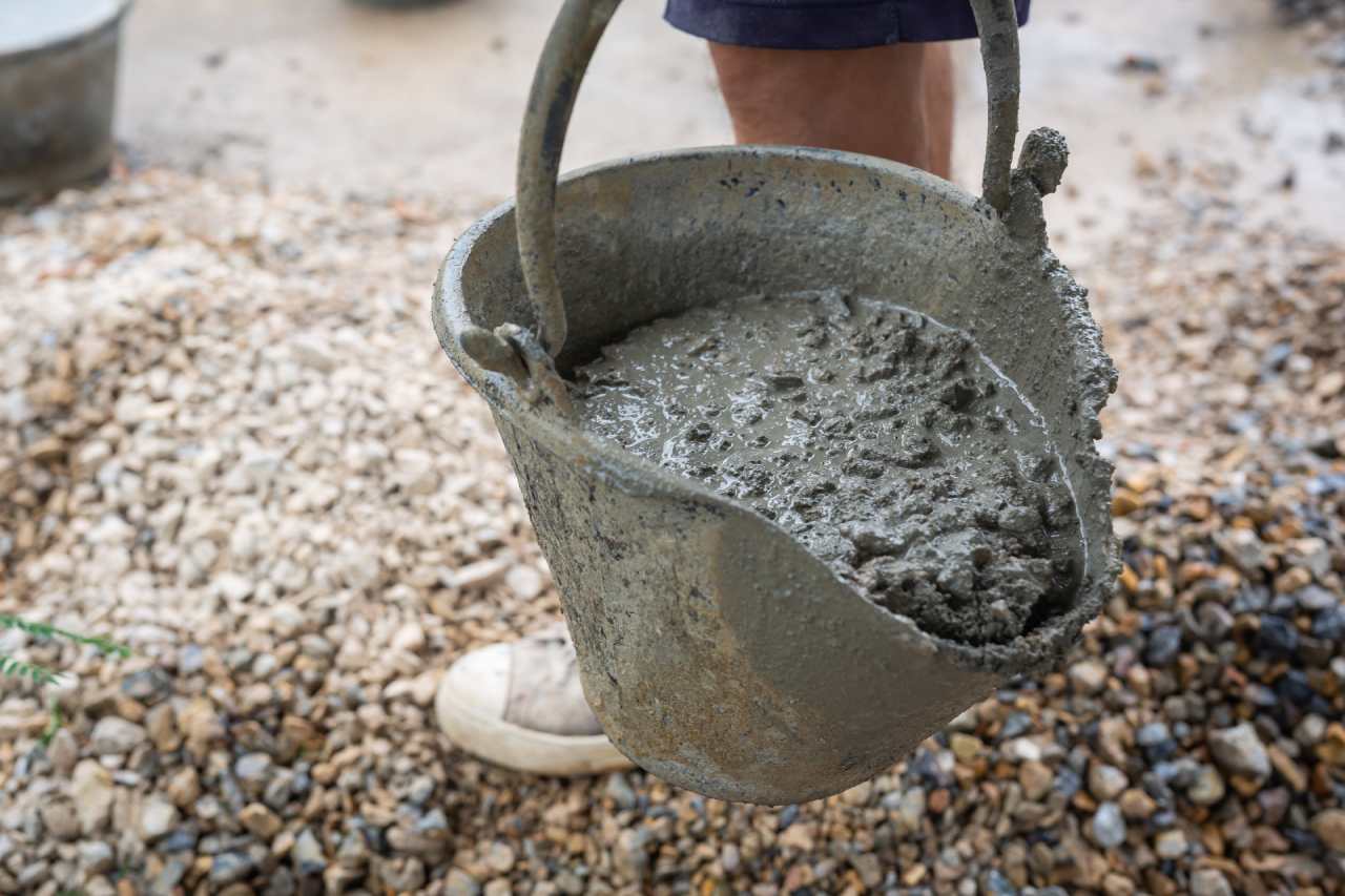 Mischen Sie den Beton in einem alten Eimer